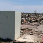A FamilySAFE storm shelter standing after a massive natural disaster