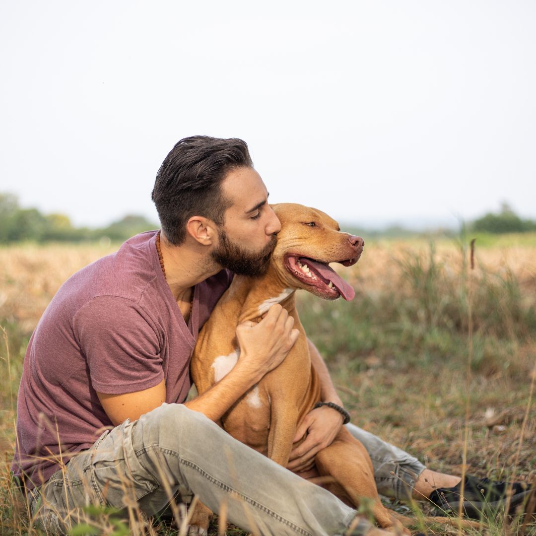 a dog owner hugging his dog