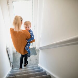 mother carrying child down stairs