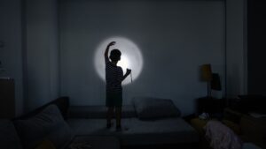child making shadows with flashlight
