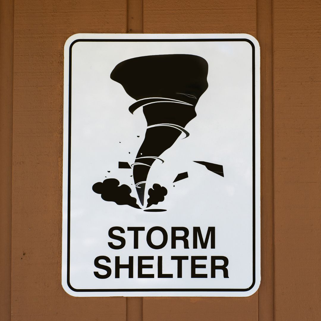Sign that reads "Storm Shelter" hung on wall
