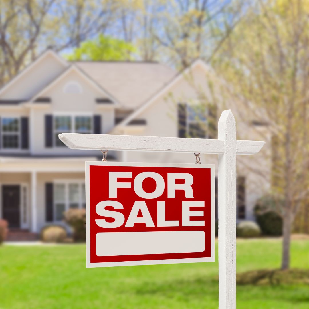 A "For Sale" sign in front of a home