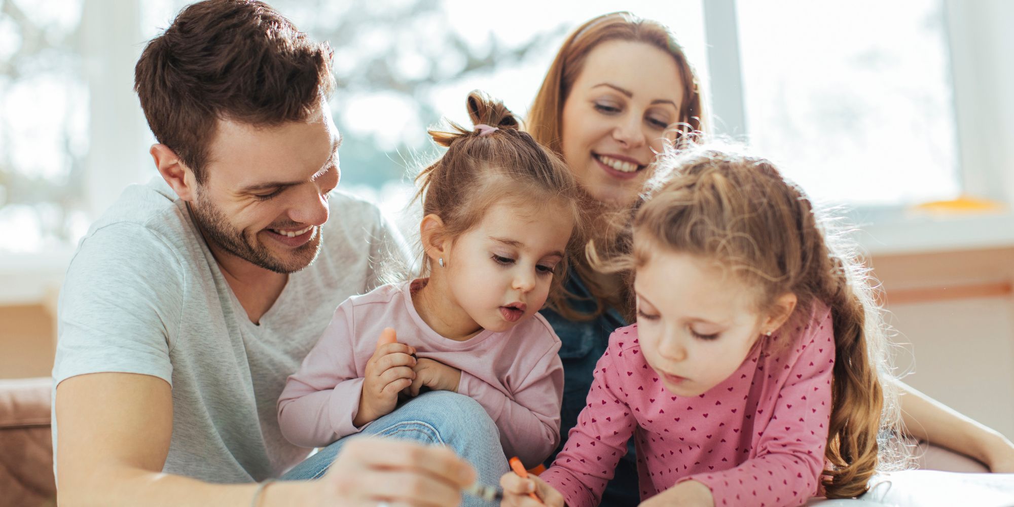 A family of four coloring with crayons