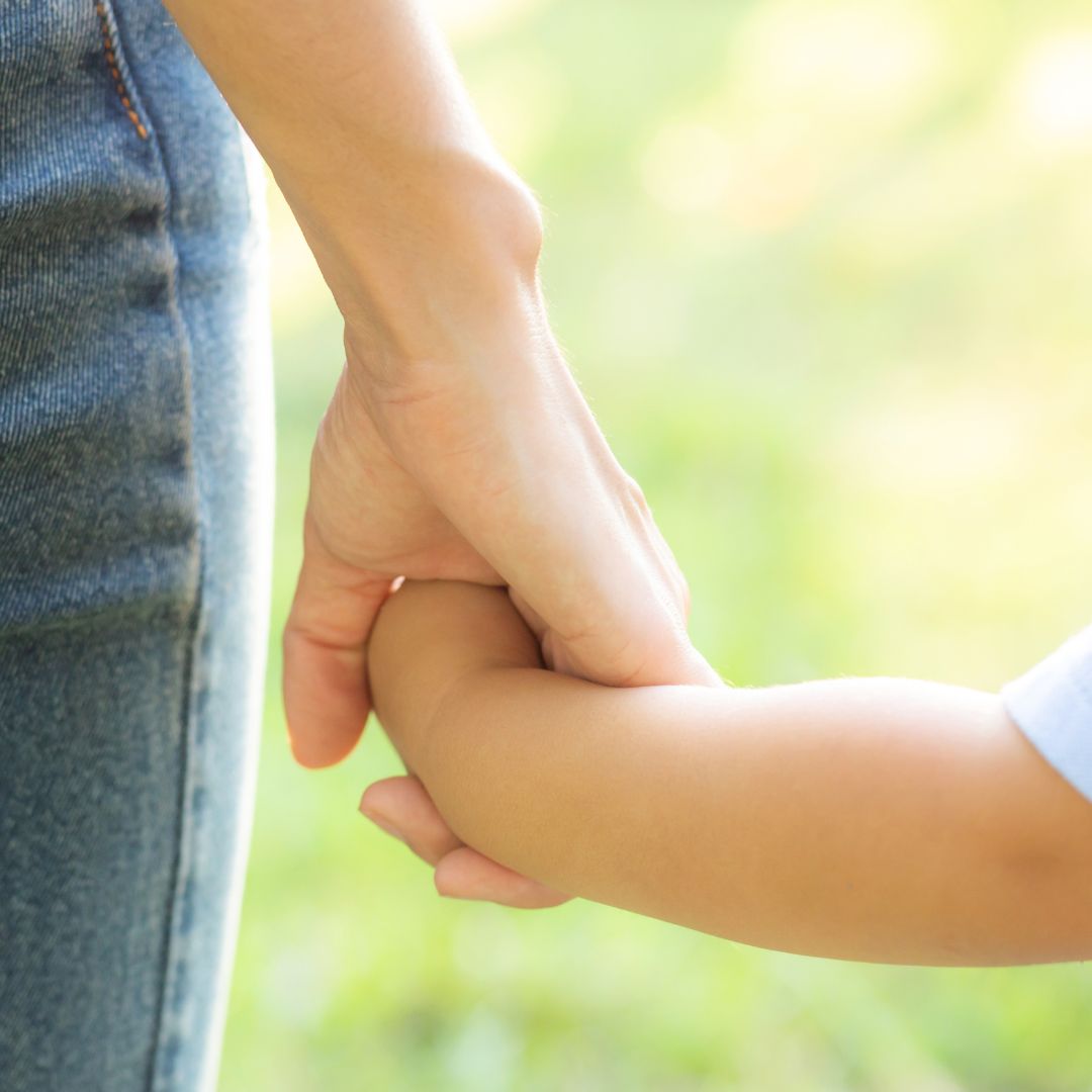 A parent and child holding hands