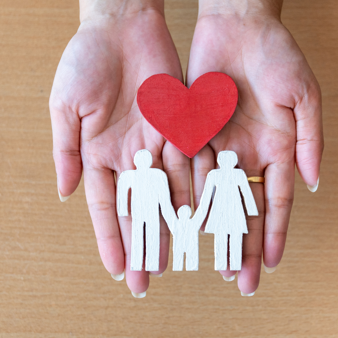 Cutout of a family with a heart above it.