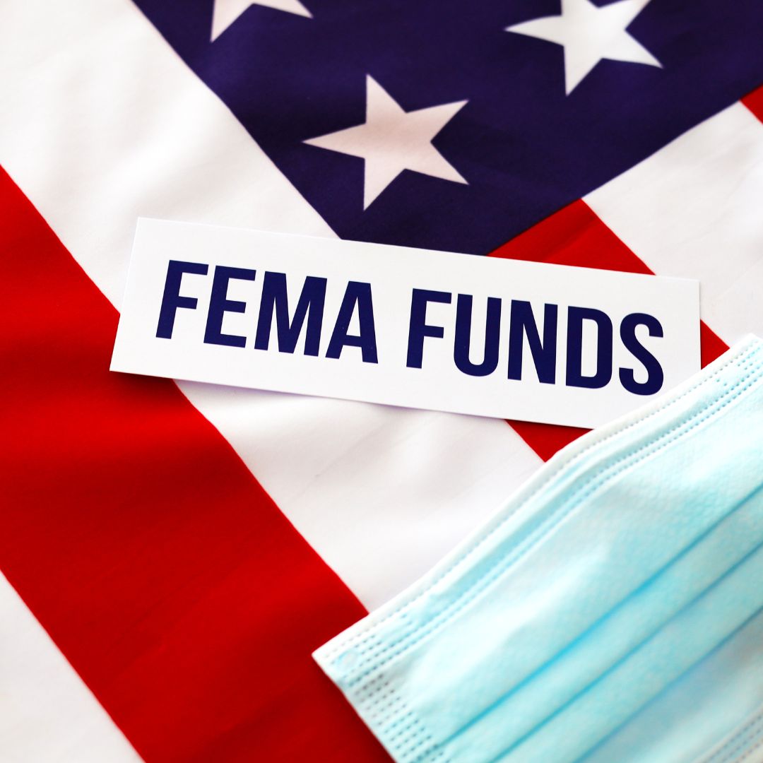 FEMA funds sign over U.S. flag and medical mask