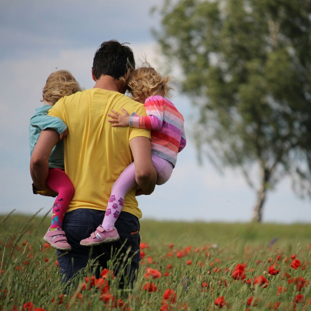 dad carrying kids in storm