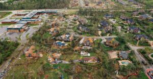 Tornado-damaged neighborhood with destroyed homes and uprooted trees