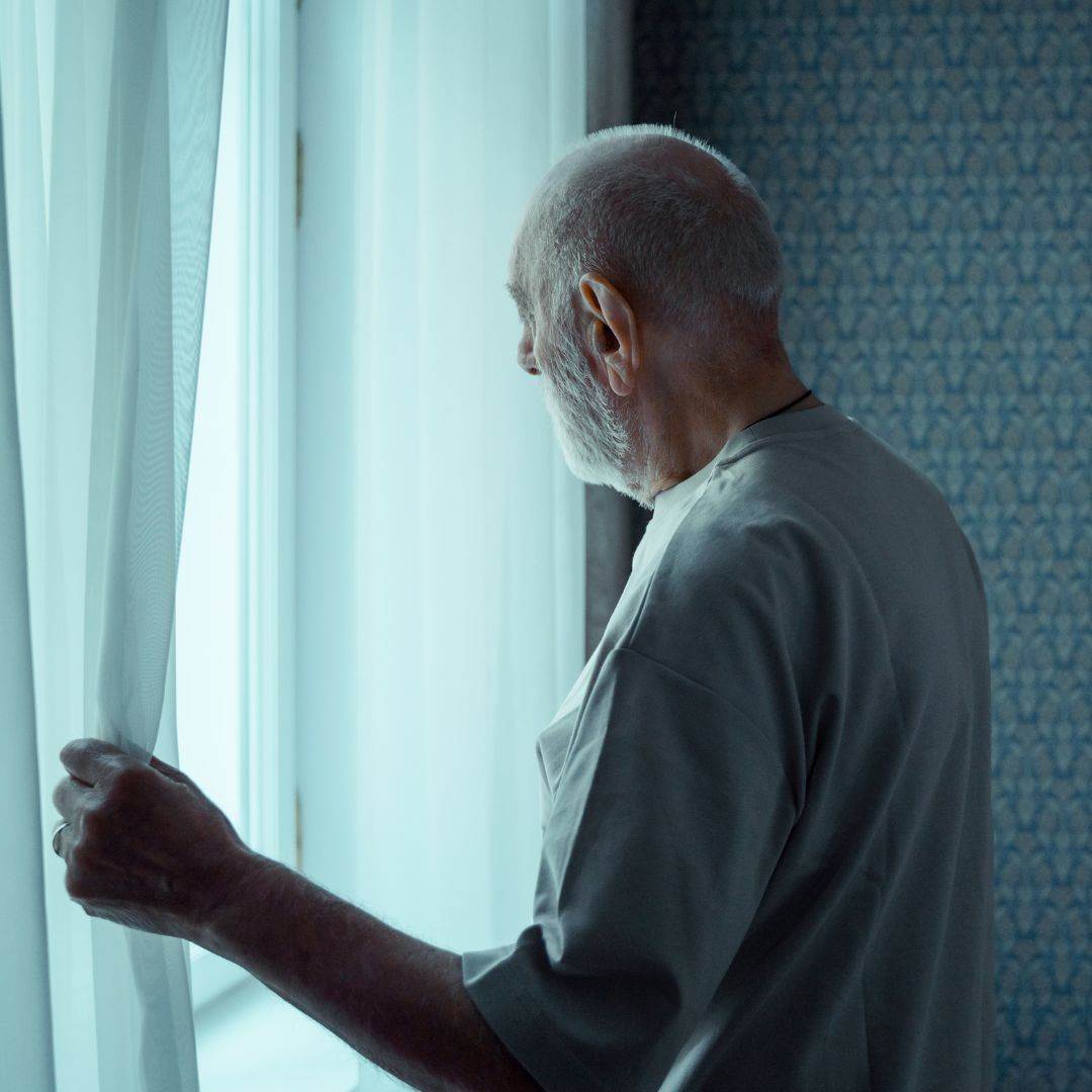 elderly man looking out window