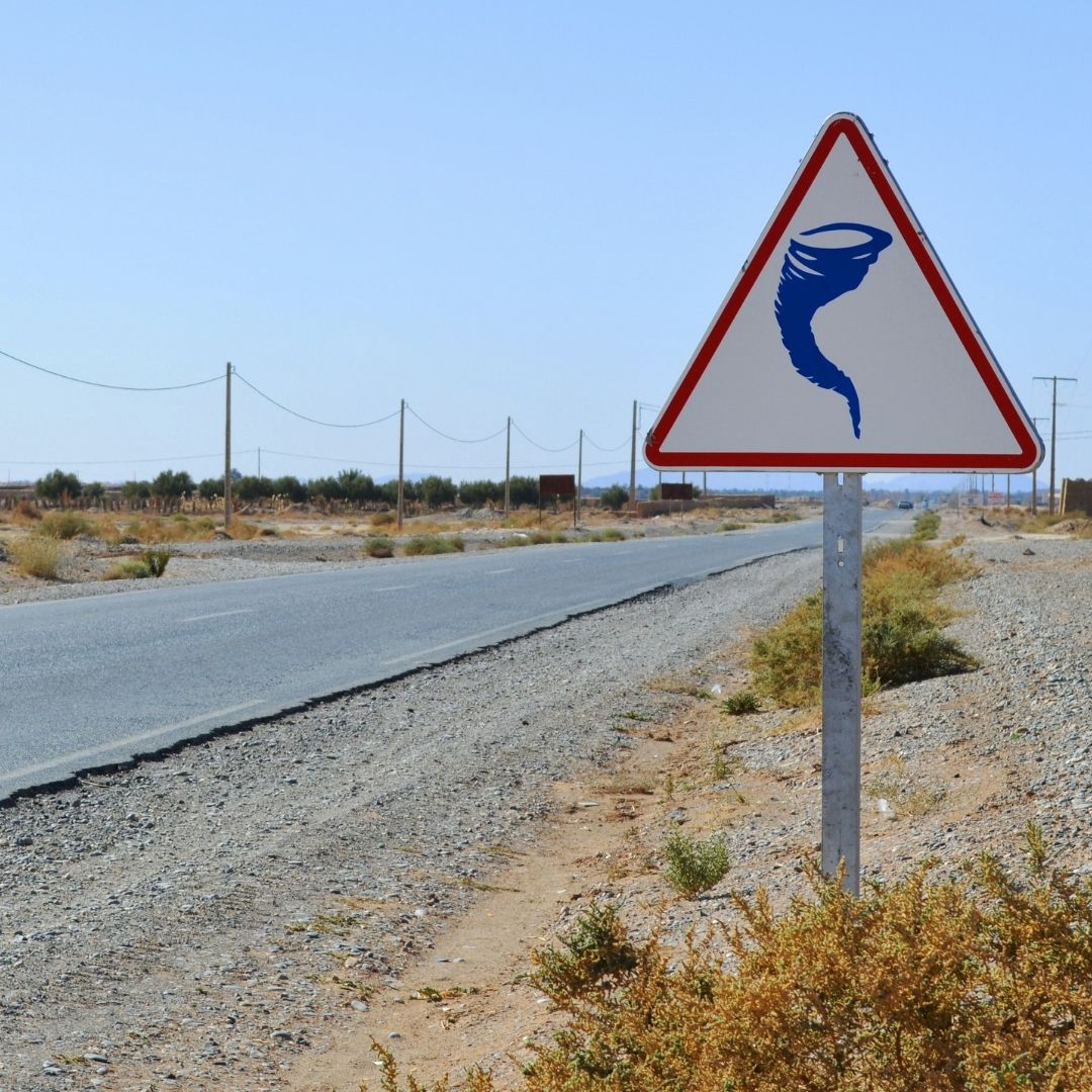 highway with a road sign with a tornado on it